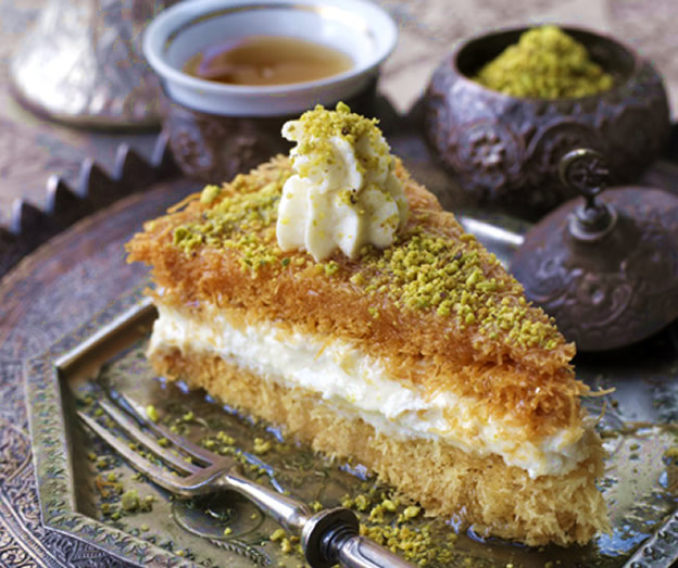 slice of nut topped cream filled cake on metal tray