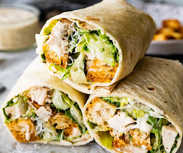 three chicken wraps with lettuce and sauce