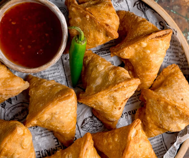 crispy golden samosas with green chilli and red sauce