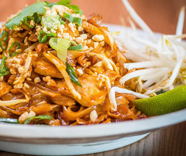 thai style stir fried noodles with peanuts and lime wedge