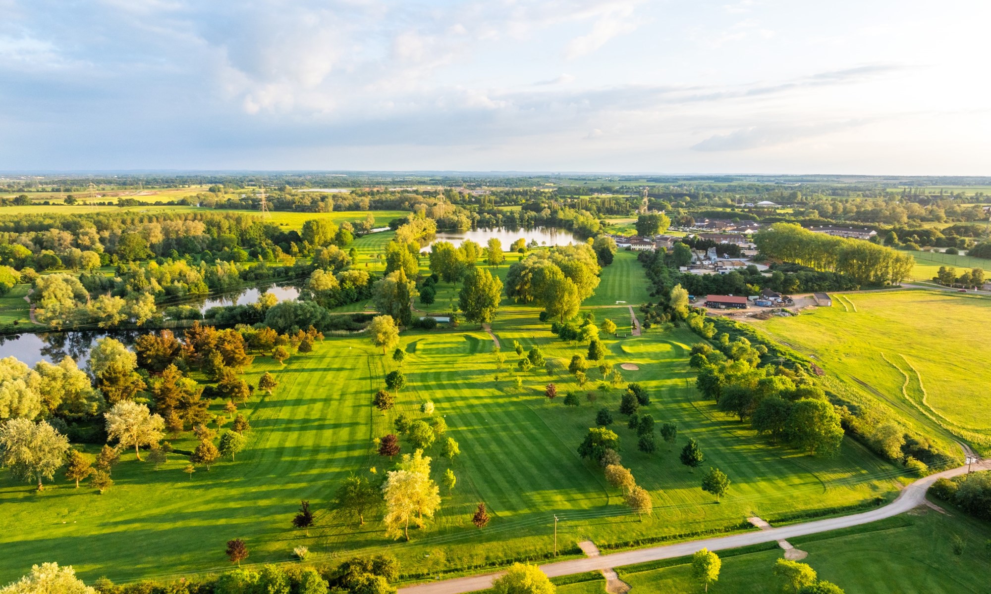 aerial view of golf course with trees and water