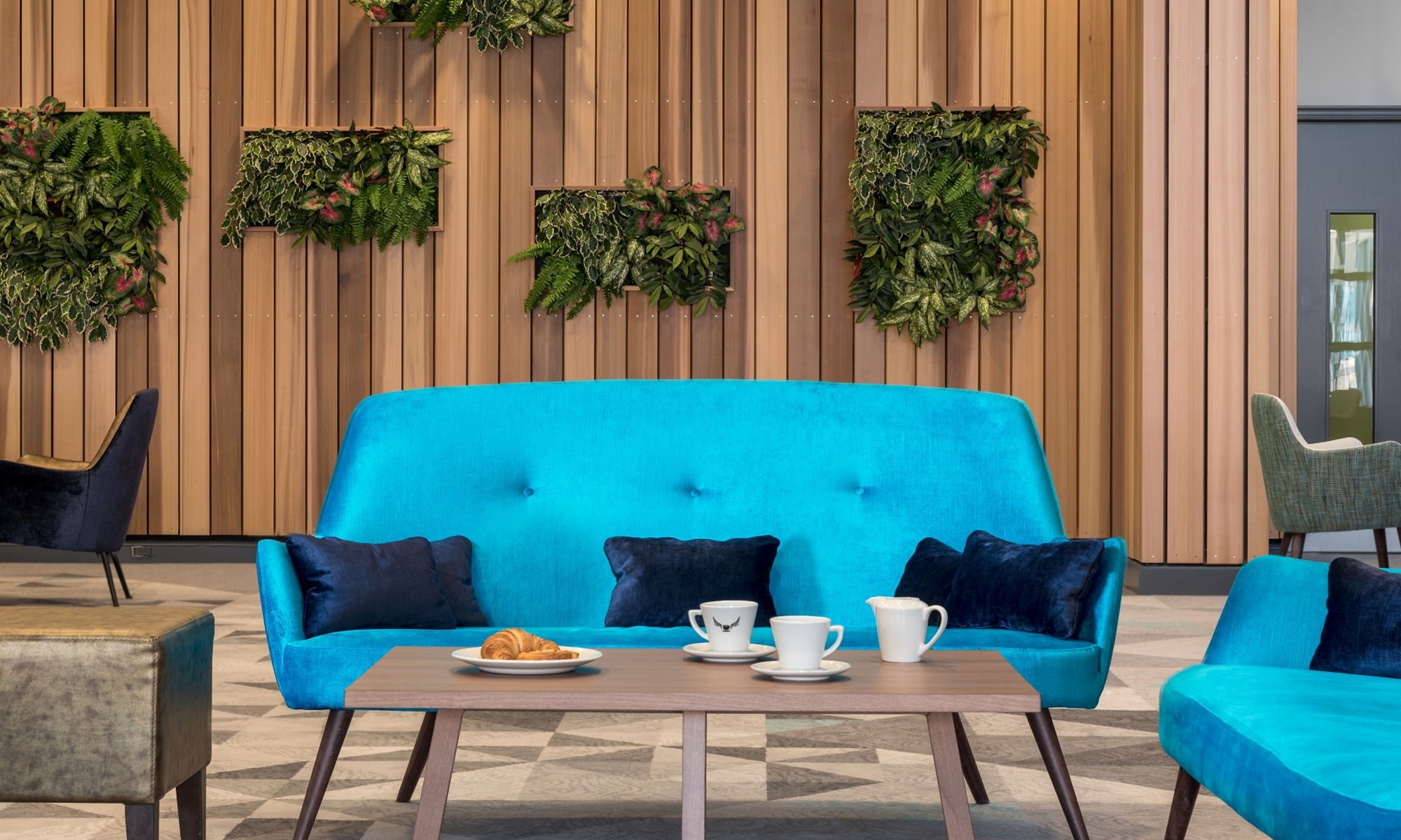 modern lounge with blue sofa wooden table and green plants