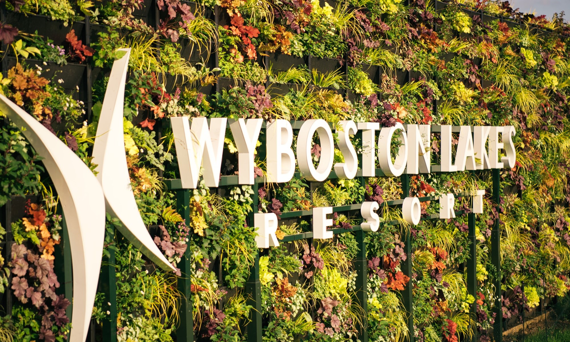 vertical garden wall with white letters and green red plants