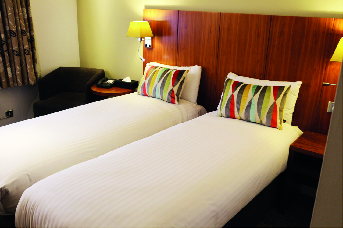 hotel room with two single beds and armchair