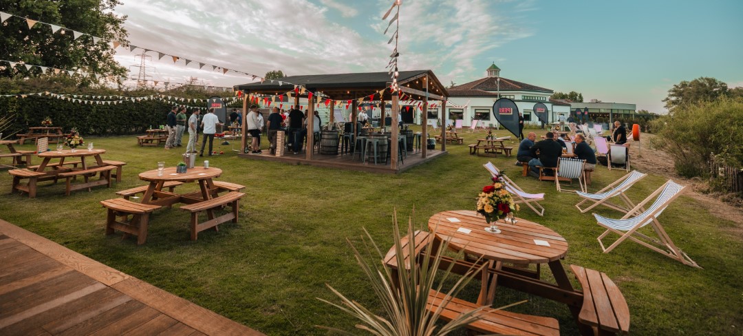 outdoor garden gathering with wooden tables and chairs