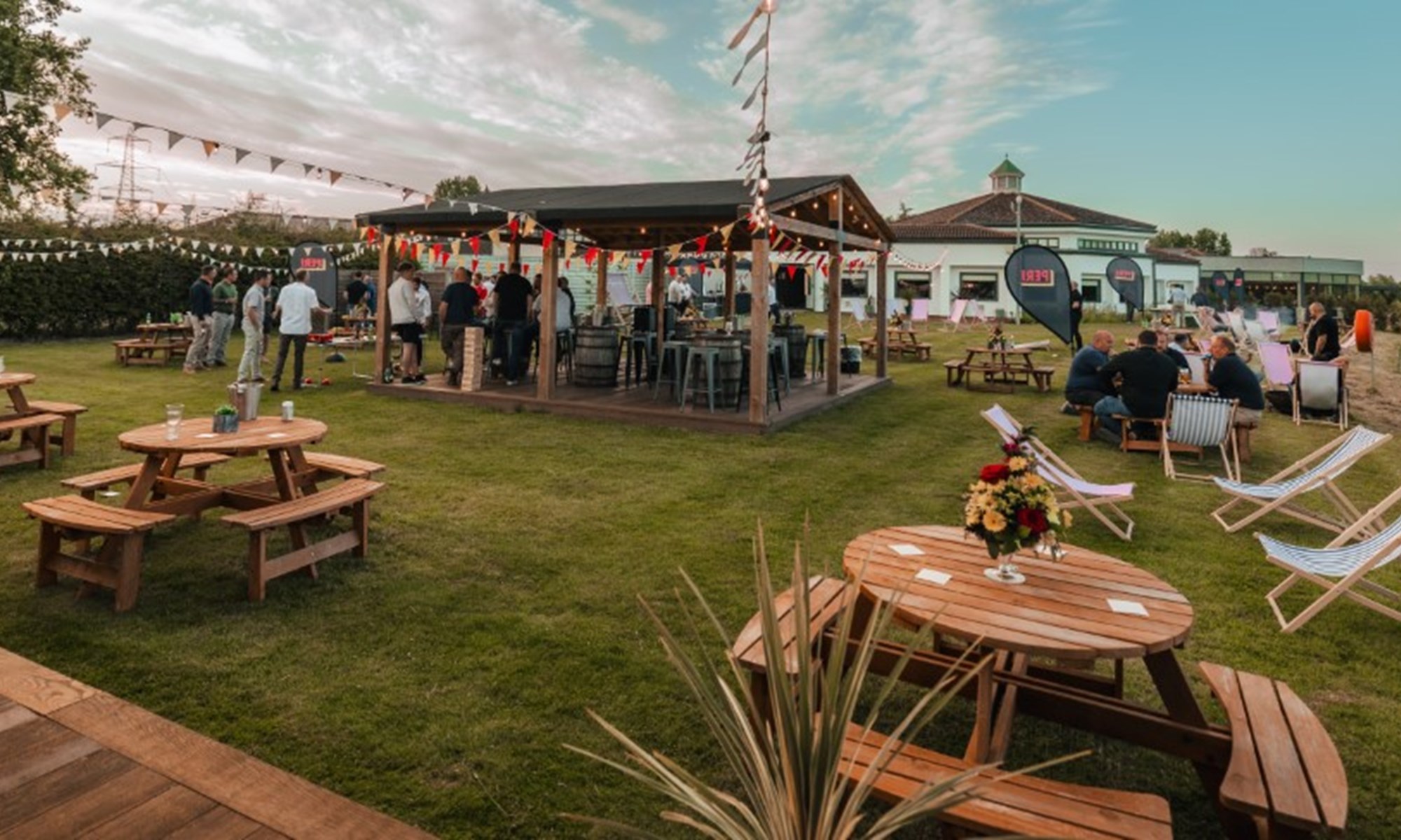 outdoor garden gathering with wooden tables and chairs