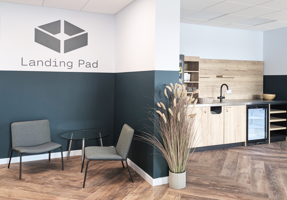 modern waiting area with two chairs glass table and kitchenette