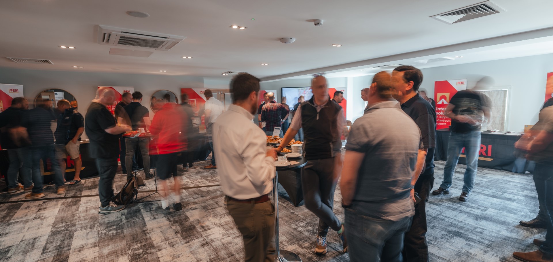 people networking at indoor event with food table