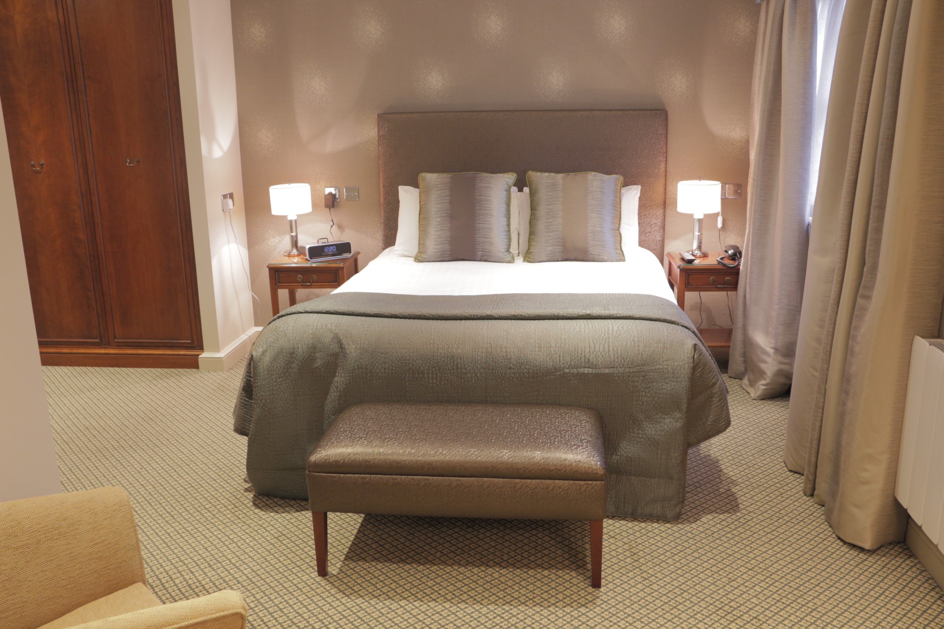 double bed with bedside tables lamps and bench seats