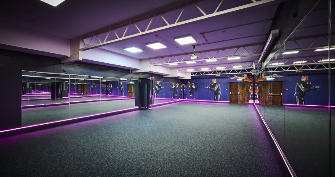 empty fitness studio with mirrored walls and neon lights