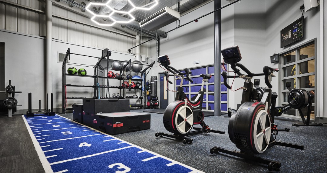 gym with exercise bikes weights and blue workout mat