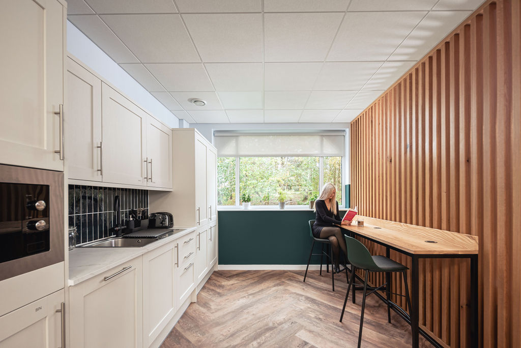 modern kitchen area with a woman reading a book