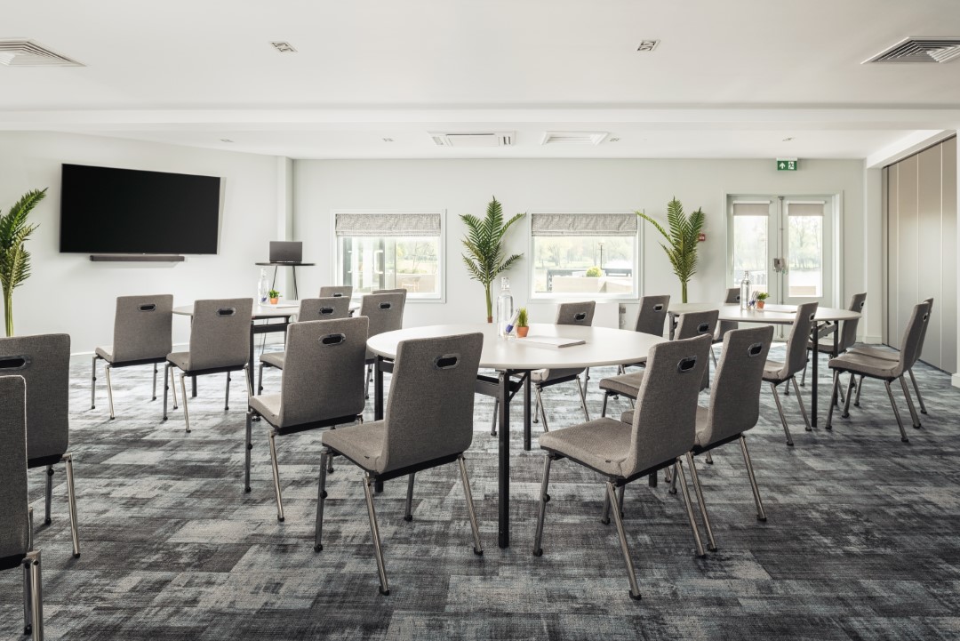 empty conference room with grey chairs and round tables