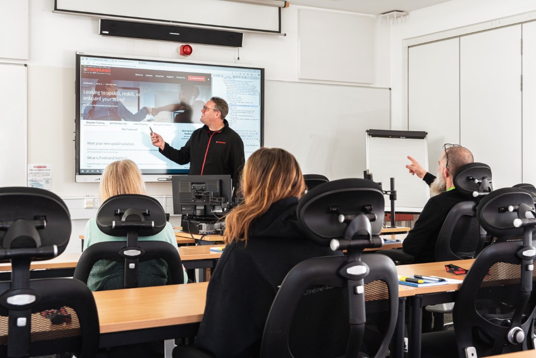 instructor teaching adults in classroom using digital screen