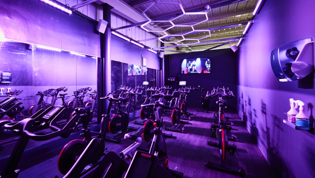 indoor cycling studio with exercise bikes purple lighting