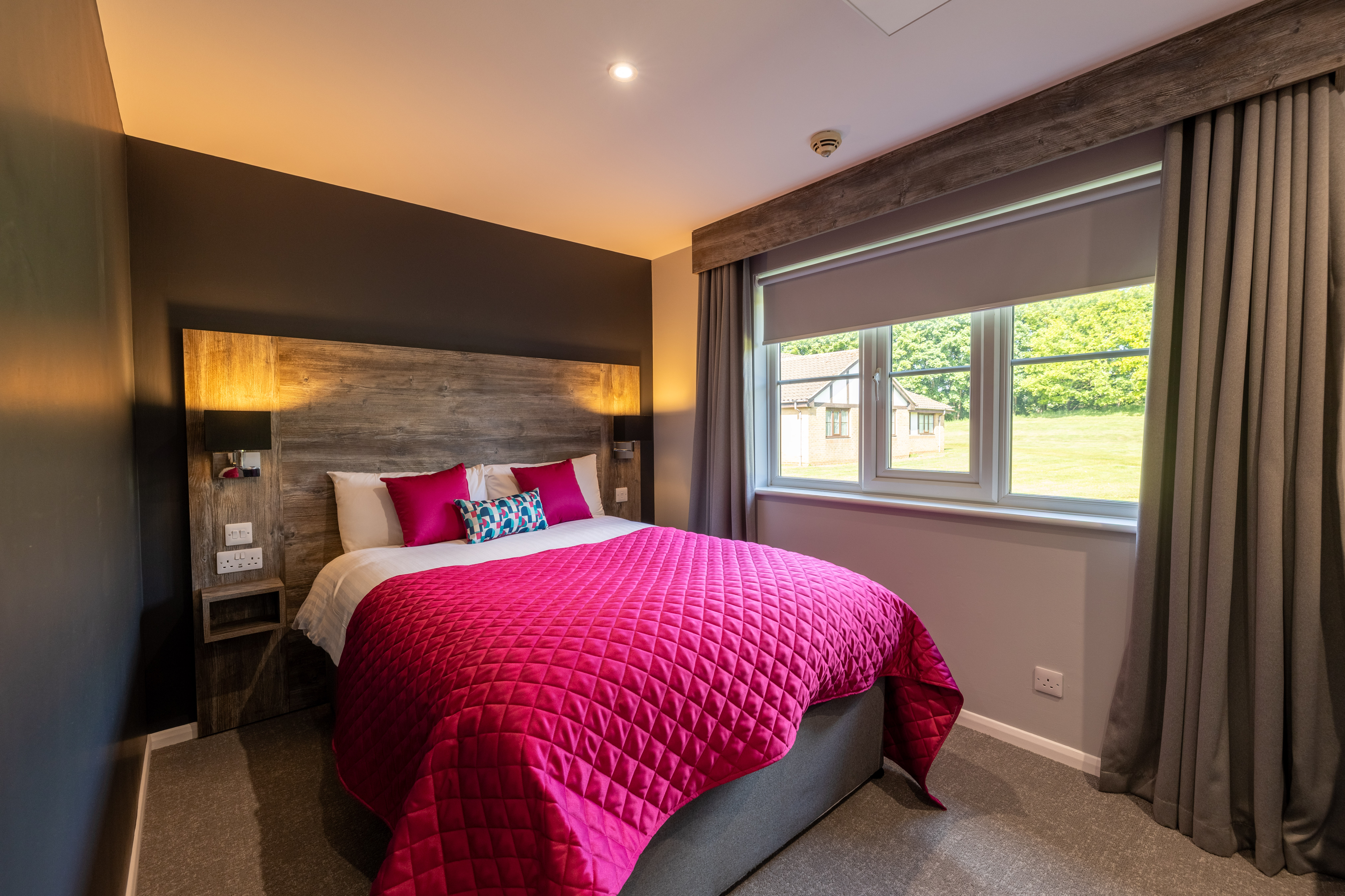 bedroom with large bed and bright pink bedspread