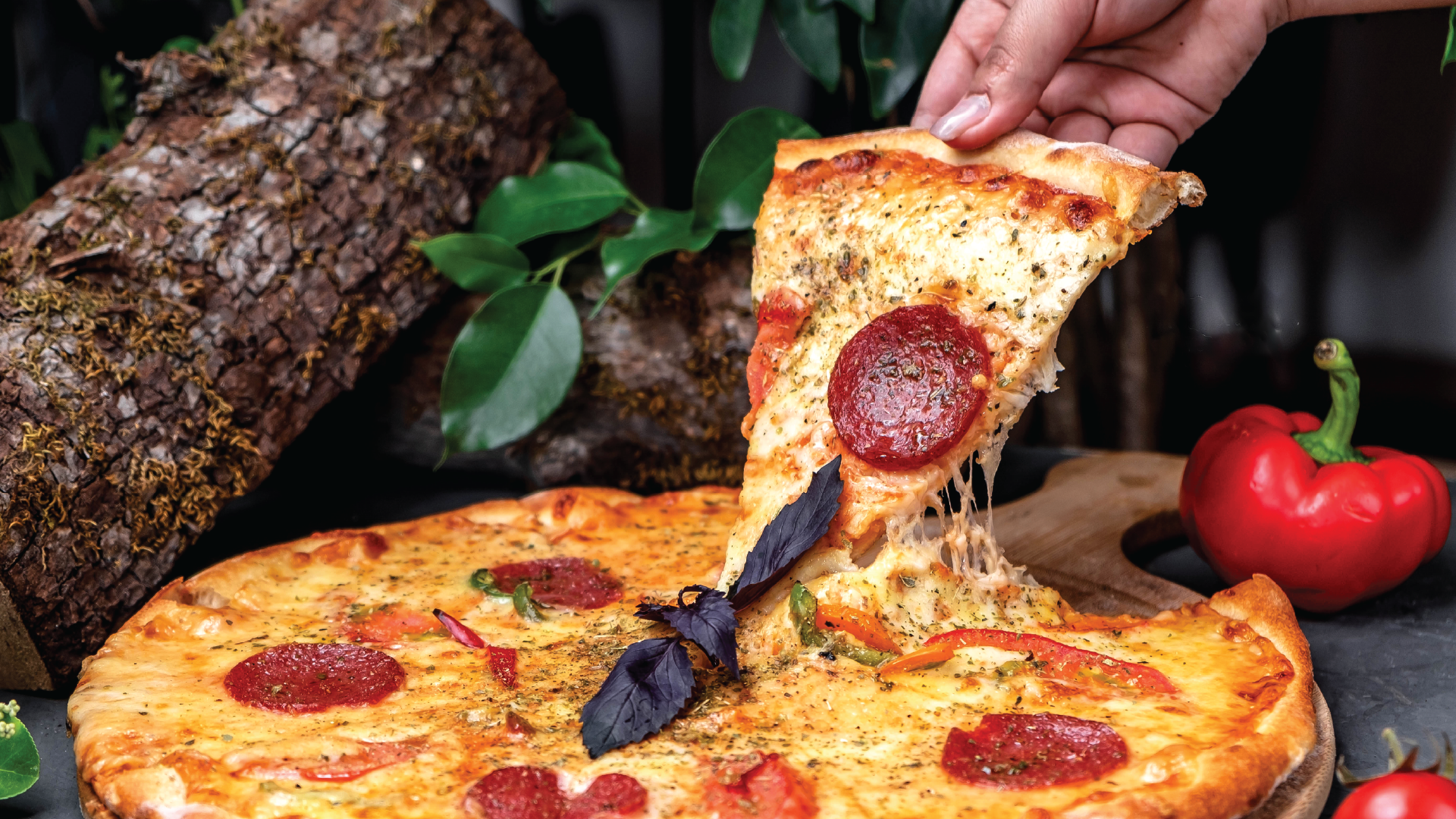 slice of pepperoni pizza being lifted from whole pizza