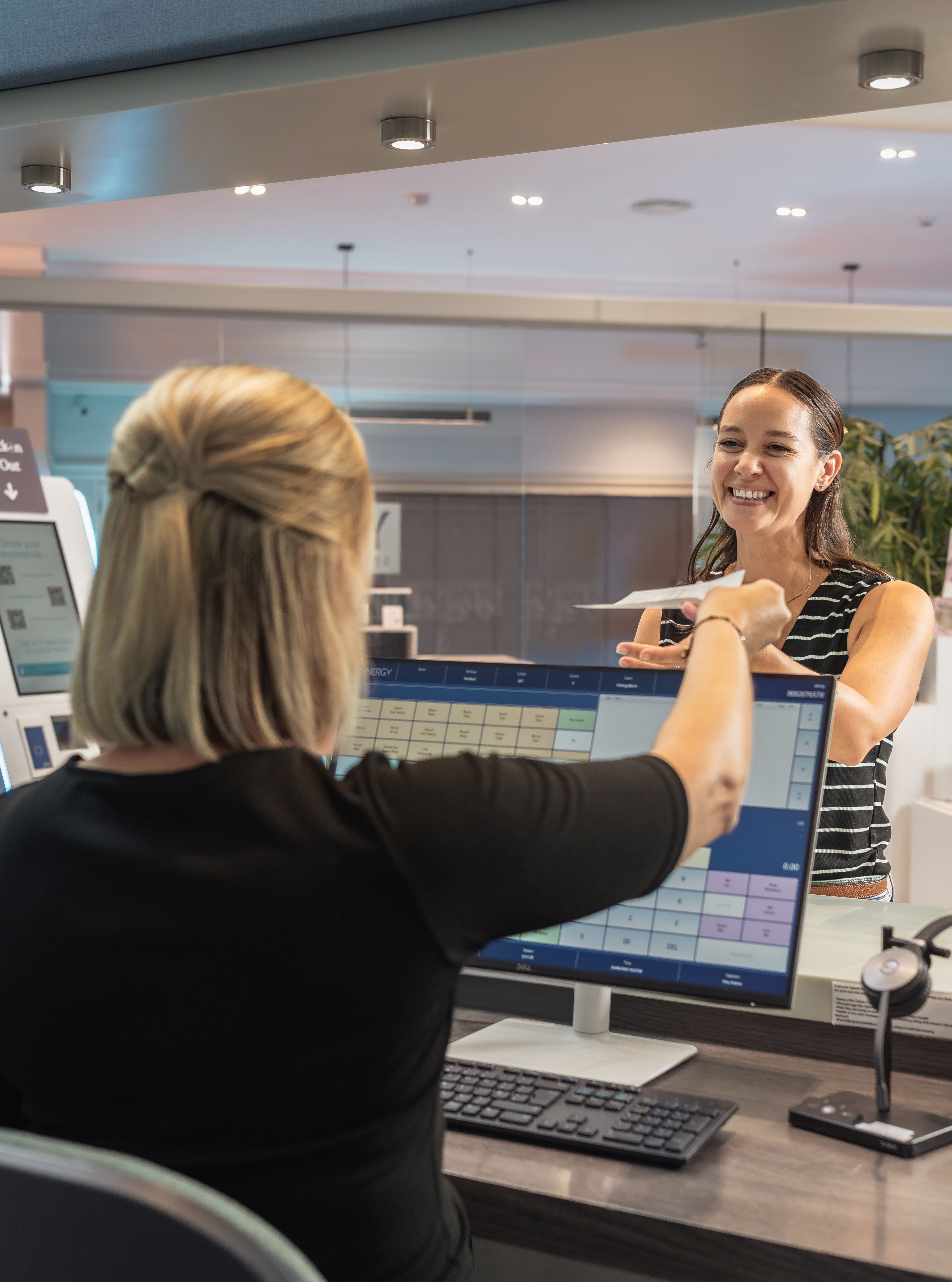 woman checking in at reception desk smiling