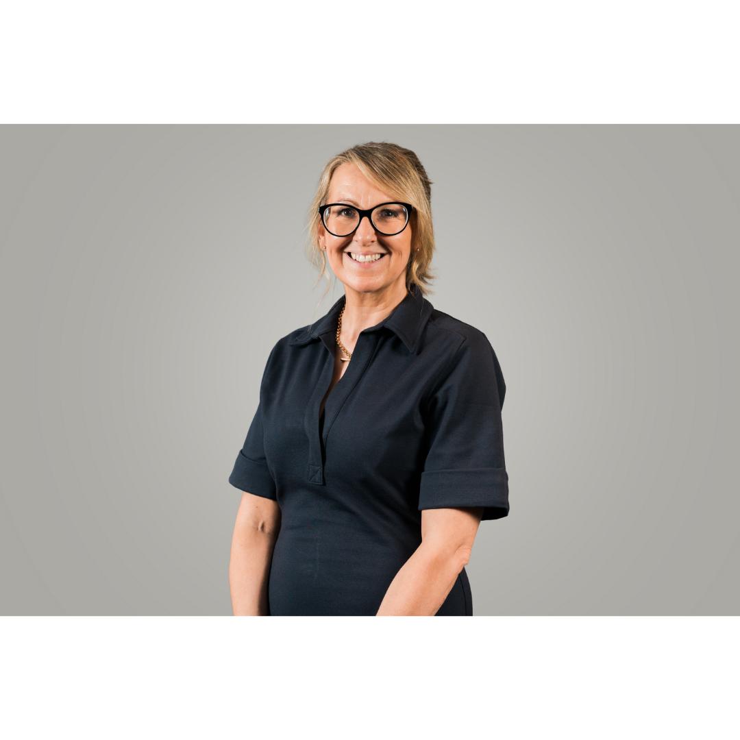 smiling woman with glasses wearing black dress