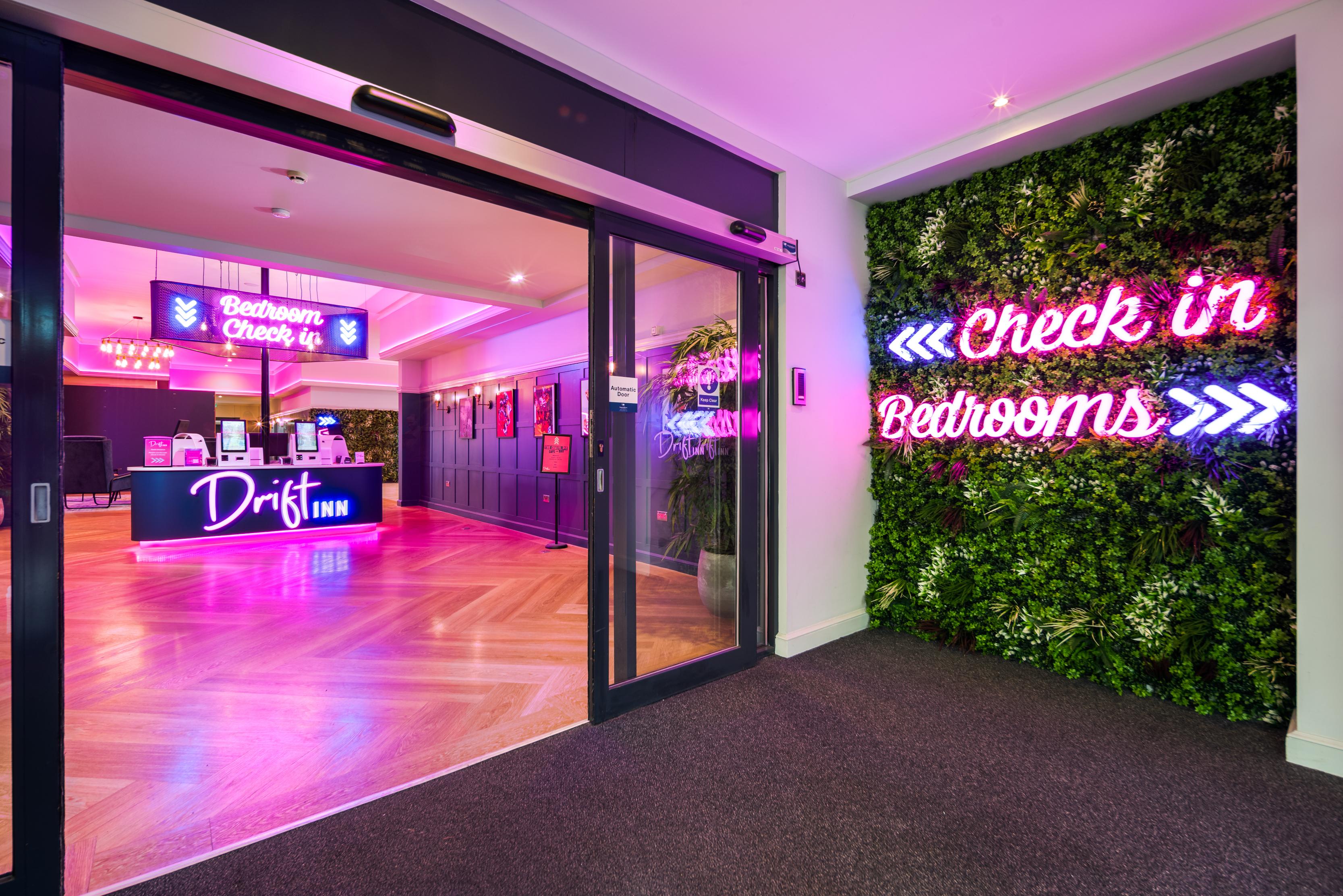 hotel reception area with neon check in signs