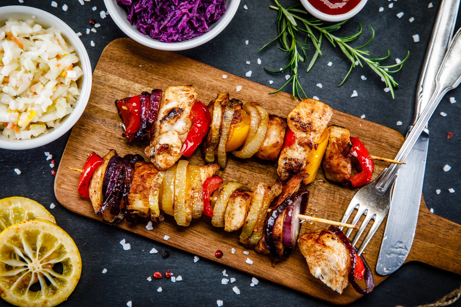 grilled chicken and vegetable kebabs on wooden board