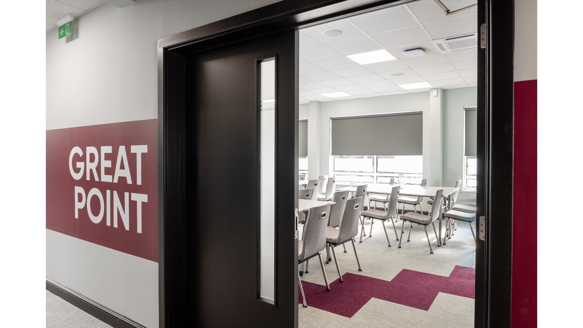 entrance to modern classroom with tables and chairs
