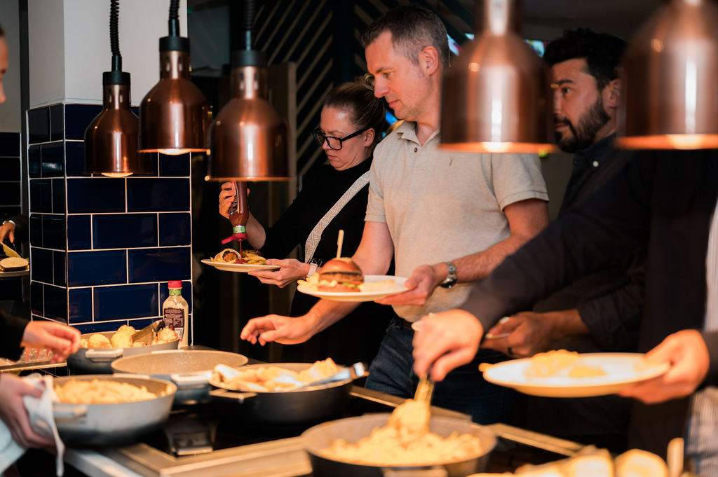 people serving food at a buffet line