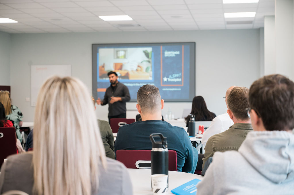 group of adults watching a presentation in a classroom