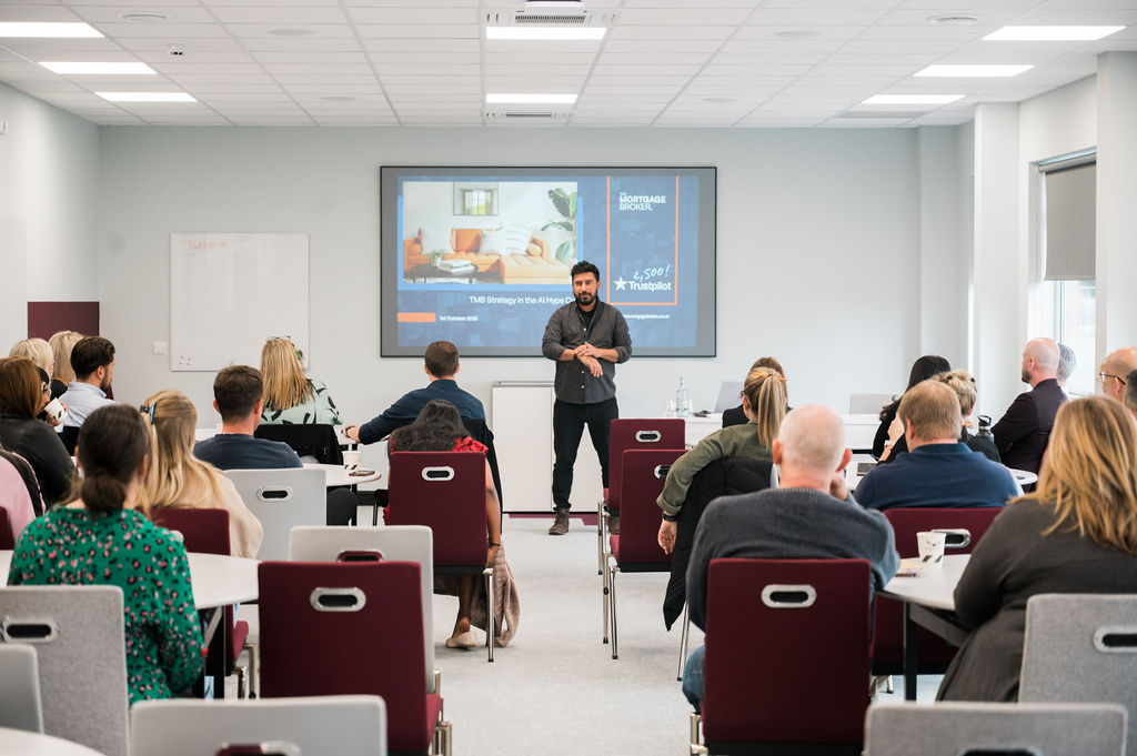 man giving presentation to seated audience in conference room