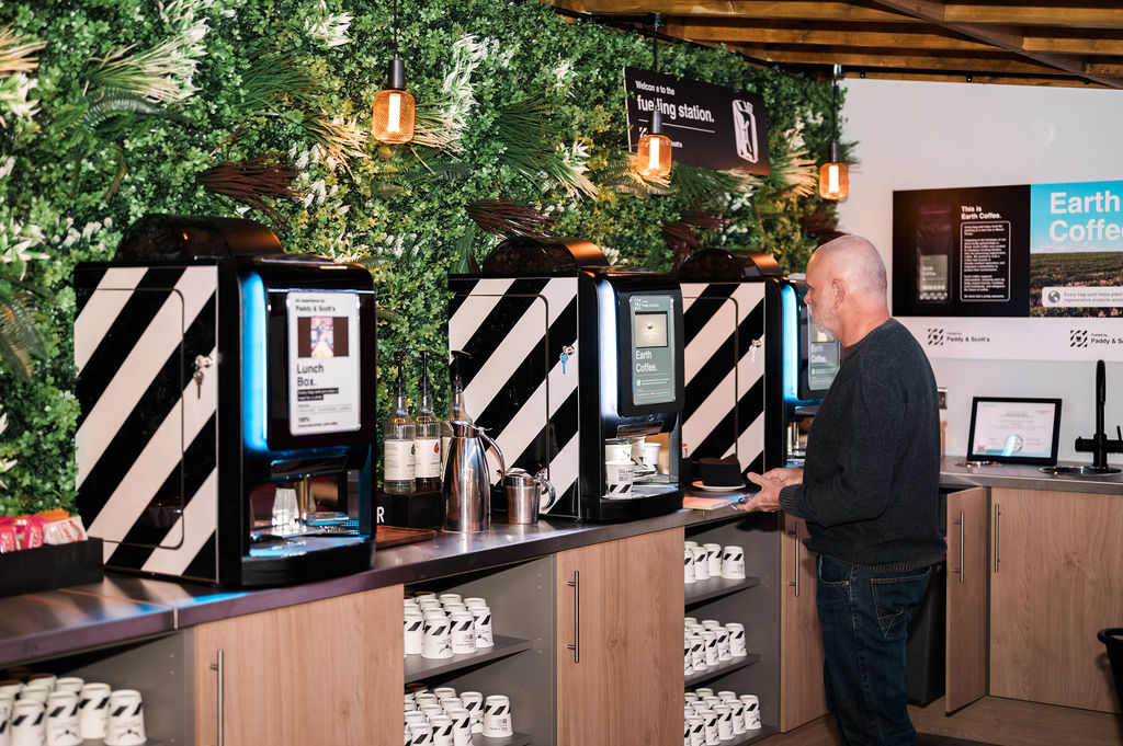 man using coffee vending machines in modern cafe