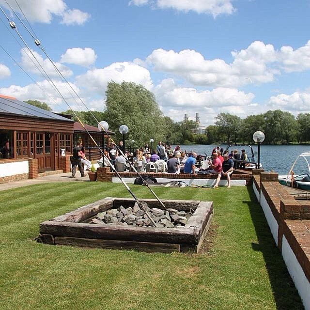 people sitting outside near river on a sunny day