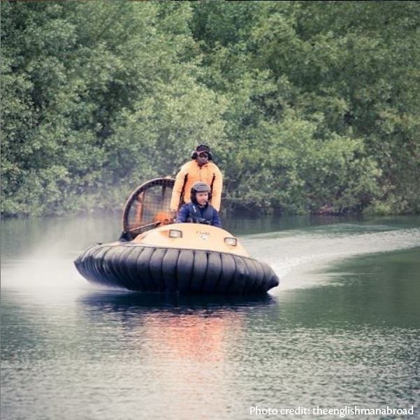 two people riding a hovercraft on water